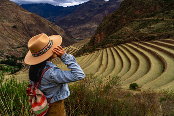 Latin tourist looking at the terraces of Pisac, Pisac archaeological complex in Cusco