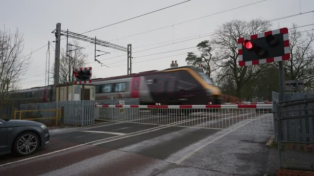 BARLASTON, STAFFORDSHIRE, ENGLAND - JANUARY 8 2025: Cross Country railway train passing through a level crossing at Wedgwood.
