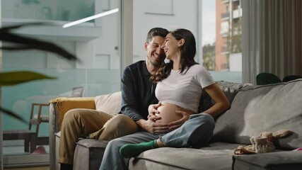 Expecting couple sitting on a cozy couch, the partner lovingly touching the pregnant belly, capturing the emotional intimacy, joy, and anticipation of welcoming a new baby into their lives - Powered by Adobe