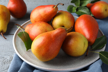 Ripe juicy pears on grey wooden table, closeup