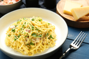 Delicious pasta Carbonara served on blue wooden table, closeup