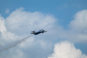 Airshow of Aero L-29 Delfín jet plane with vapor trails on cloudy sky background