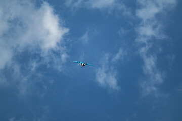 Yak-52 aircraft plane flying aerobatics in cloudy blue sky at airshow
