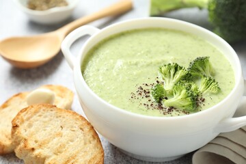 Delicious broccoli cream soup served on light table, closeup