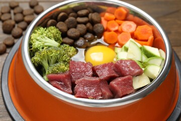Dry pet food and natural products on wooden table, closeup