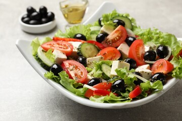 Delicious fresh Greek salad on grey table, closeup