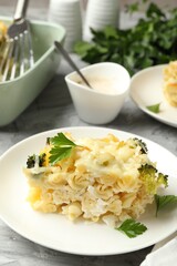 Tasty pasta casserole with cheese and broccoli served on grey table, closeup