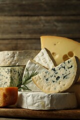 Different types of cheese and rosemary on table, closeup