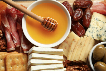 Different types of delicious cheese and other snacks as background, top view