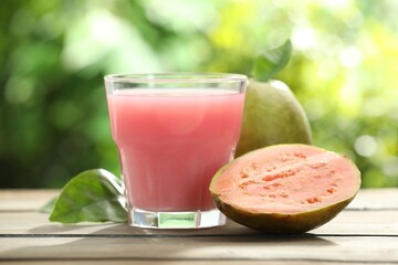 Refreshing guava juice and fresh fruits on wooden table, closeup