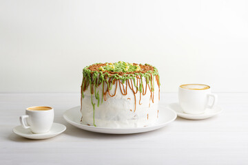 Homemade cake and two cups of coffee cappuccino and espresso on white wooden table. Copyspace.