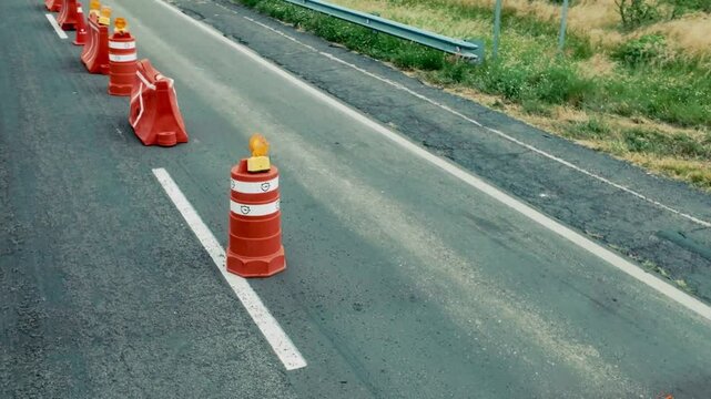 Road construction with safety cones marking work zone on highway