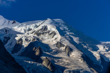 Fototapeta premium View of snow mountain glaciers at the high altitude in the Alps. Stunning mountain landscape with high snow peaks and summits of Mont Blanc mountain range from Aiguille du Midi summit