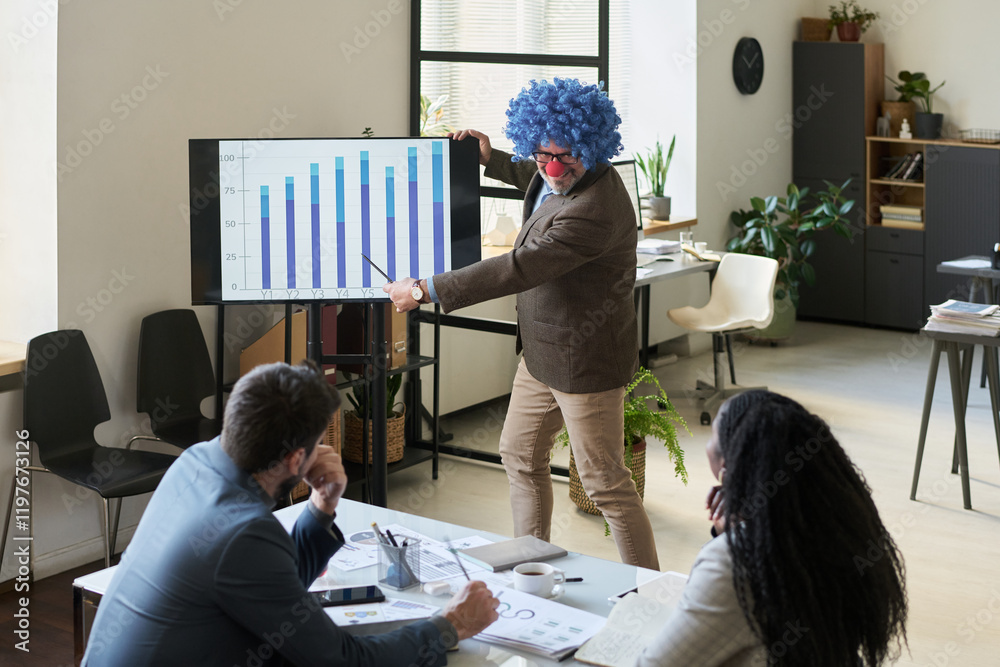 Poster Smiling male boss in clown wig pointing at graphic data on interactive board while explaining it to intercultural subordinates