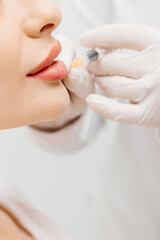 A beautician performing beauty injections on a young woman in a modern cosmetic clinic. Concept of skin rejuvenation, cosmetic procedures, and non-surgical facial enhancements for a youthful look.