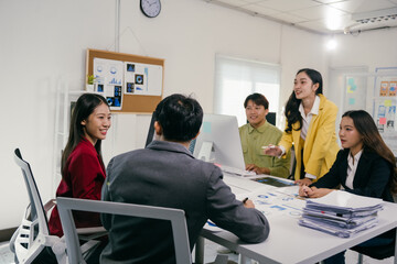 Five business professionals collaborating on a project, analyzing data and discussing strategies during a productive office meeting, fostering teamwork and innovative solutions