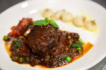 Plato de carne guisada con verduras y ñoquis