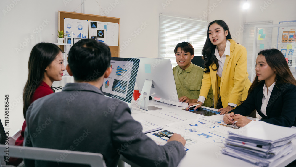 Poster Group of young asian businesspeople working and discussing using computer and documents showing graphs and charts in a meeting room at the office