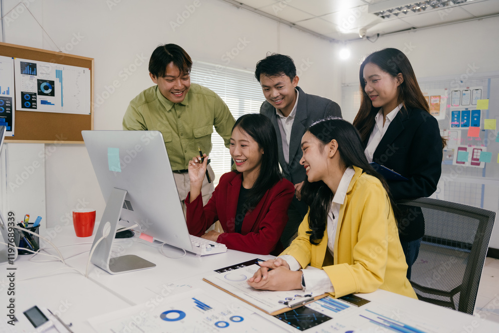 Poster Group of young asian professionals collaborating on a project, analyzing charts and data on a computer screen during a productive meeting in a modern office