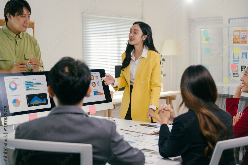 Poster young asian businesswoman pointing at computer screen showing charts and graphs, presenting project 