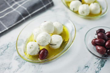 Labneh cheese balls from goat milk with herbs, marinated in olive oil, with olives on the side