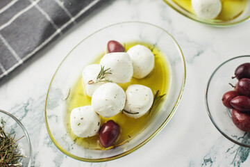 Labneh cheese balls from goat milk with herbs, marinated in olive oil, with olives on the side