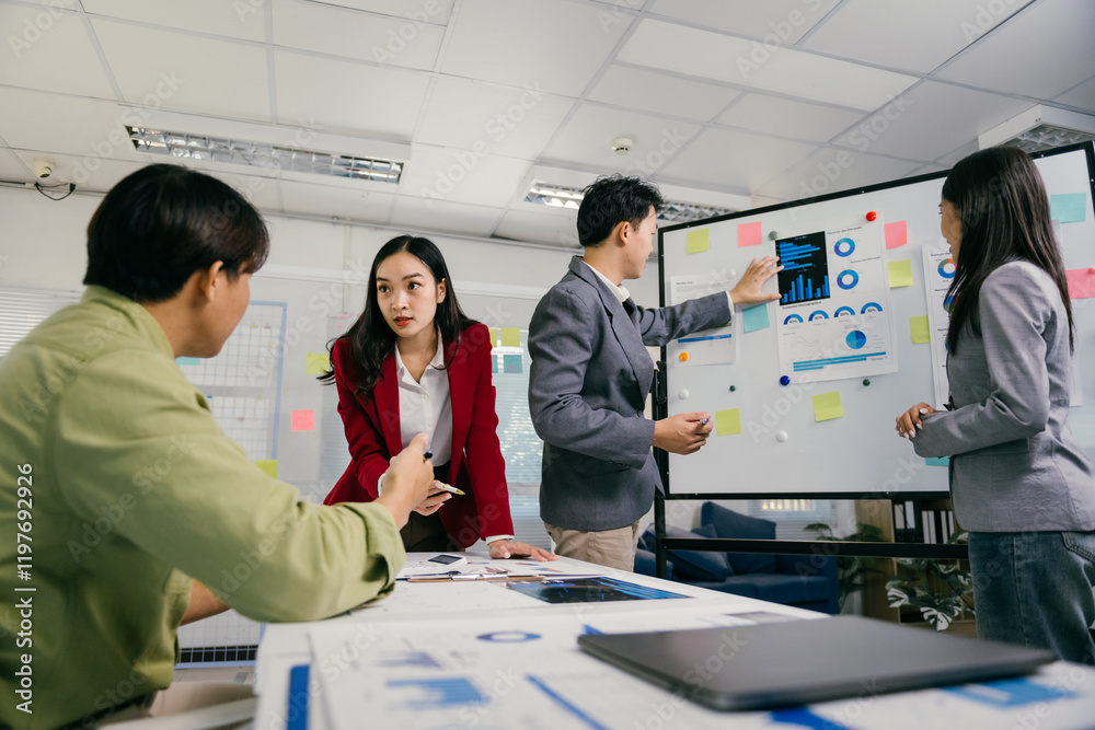 Poster Four asian businesspeople are discussing data displayed on a whiteboard, analyzing charts and graphs together in a modern office environment during a productive meeting