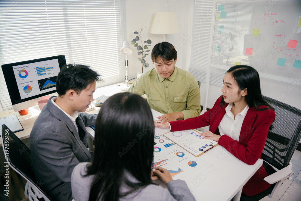 Leinwandbilder Asian businesspeople having a meeting in modern office, analyzing charts and graphs using data displayed on computer screen and printed documents, collaborating on business strategy and planning
