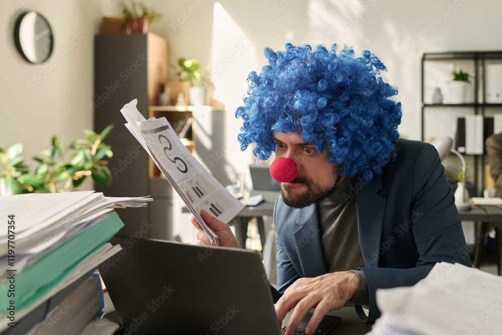 Poster young clown businessman with financial paper documents in hand looking at laptop screen and typing w