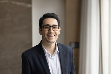 Profile picture of smiling confident Arabic businessman in formal jacket looking at camera for...