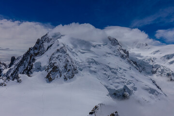 View of snow mountain glaciers at the high altitude in the Alps. Stunning mountain landscape with high snow peaks and summits of Mont Blanc mountain range from Aiguille du Midi summit