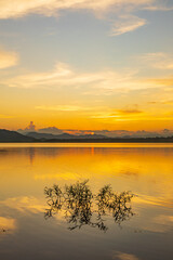 Landscape of mountains and lake at sunset and clouds reflected in the water.