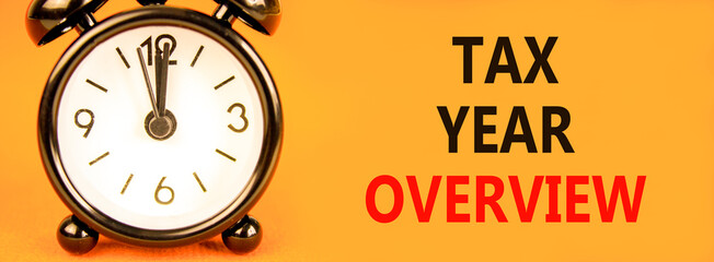 Tax year overview symbol. Concept words Tax year overview on beautiful orange paper. Beautiful orange background. Black alarm clock. Business tax year overview concept. Copy space.