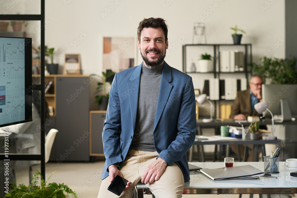 Poster young successful director of business company with mobile phone looking at camera while sitting on h