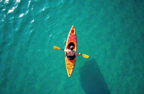 Banner. An overhead view of a man paddling a bright yellow kayak on clear azure water. 