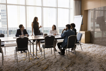 Attractive businesslady, trainer or business coach make speech during corporate briefing event...
