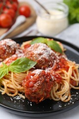Delicious pasta with meatballs, basil and cheese on white table, closeup