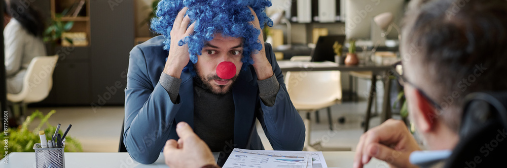 Aufkleber header of young stressed businessman in clown wig and nose sitting in front of boss and holding head