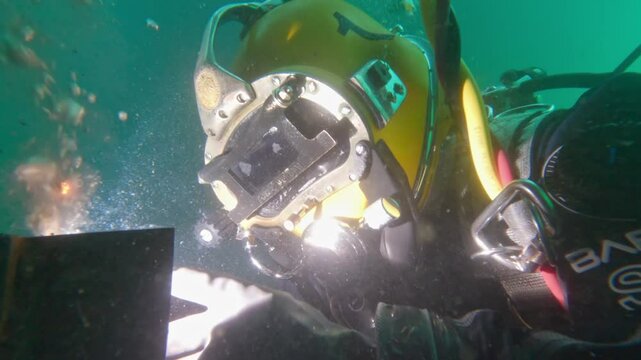 Commercial diver wet welding underwater closeup