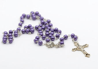 A purple beaded rosary isolated on a white background.