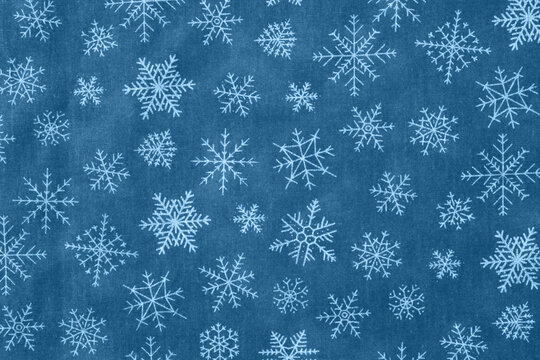 A festive background with snowflakes on a blue wintery pattern. Perfect for holiday designs and seasonal projects
