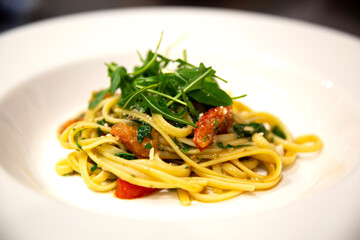 Plato de pasta italiana con tomates y rúcula