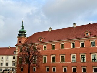 view of the royal palace of warsaw with its tower and clock in the old town on a cold winter day
