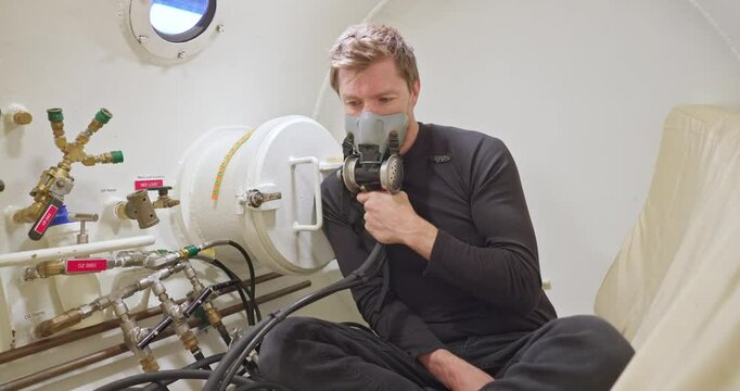Man in hyperbaric chamber using BIBS mask closeup