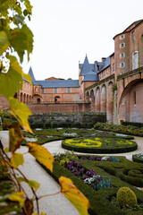 Ornate Formal Gardens in Albi, France with Historic Red-Brick Architecture in the Background