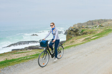 Fototapeta premium Young lady with bicycle on a sea
