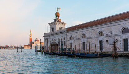 Naklejka premium Gondola docks at Punta della Dogana during sunset