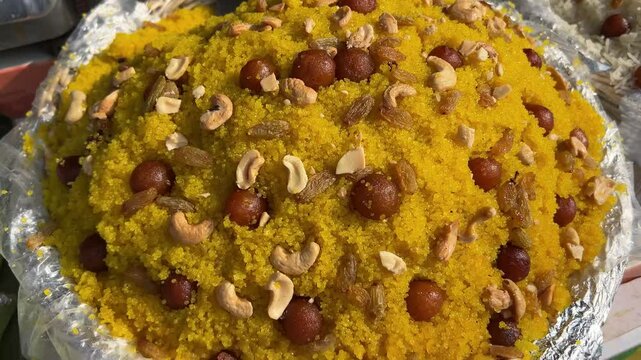 Yellow colored Bengali sweet dish Mihidana prepared with small gulab jamun and cashew.