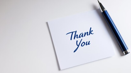 Simple thank you note with a blue pen on a clean white surface for expressing gratitude