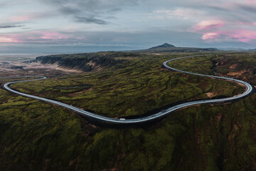 Aerial view of Iceland's Route 1 winding through Hellisheidi, surrounded by vibrant volcanic...